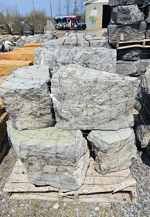 Grey stackable limestone on pallets in the yard