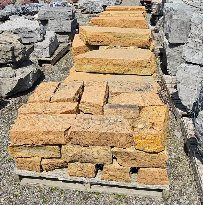 Tan wall stone on pallets in the yard